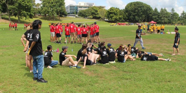 Multiple sports teams talking amongst themselves on a sports field.