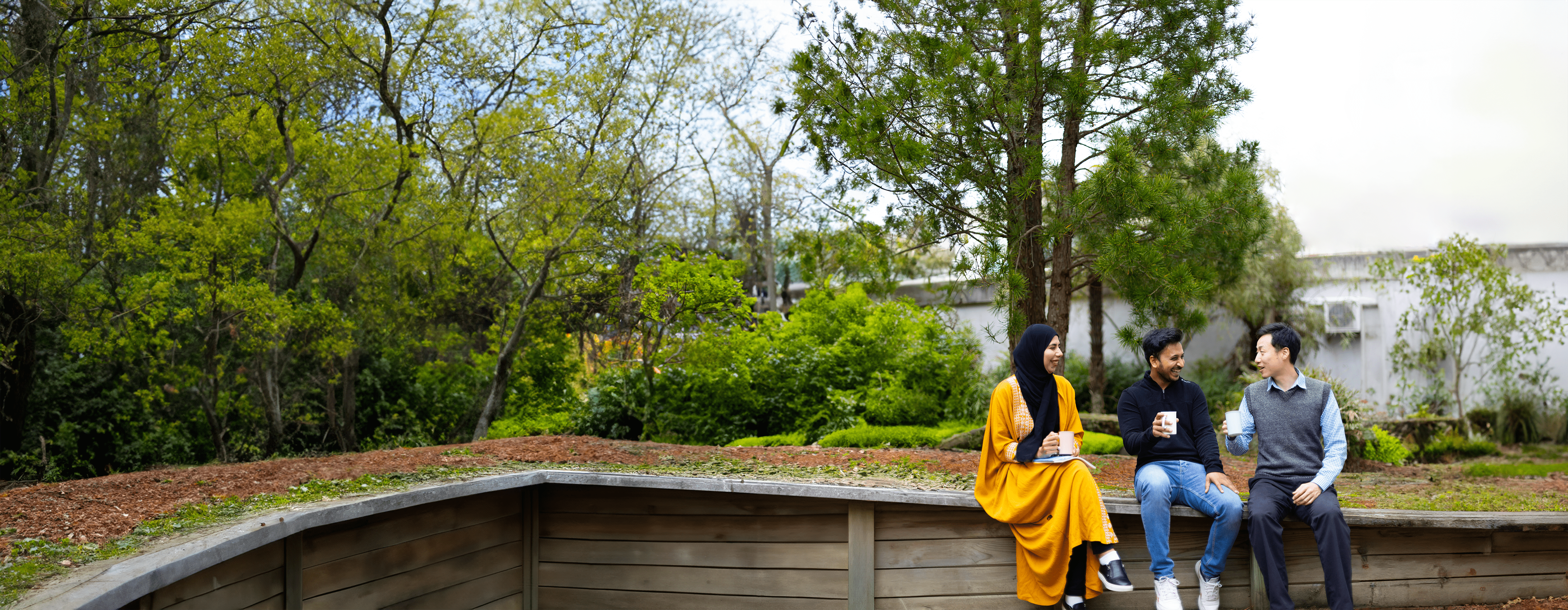 postgrad students sitting outside forest